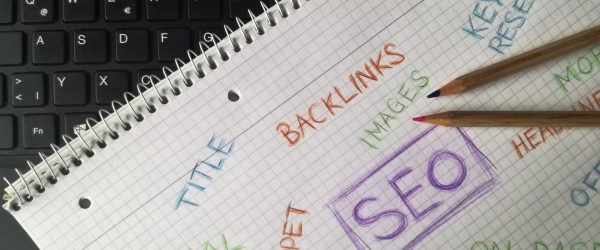 Close-up of notebook with SEO terms and keywords, highlighting digital marketing strategy.